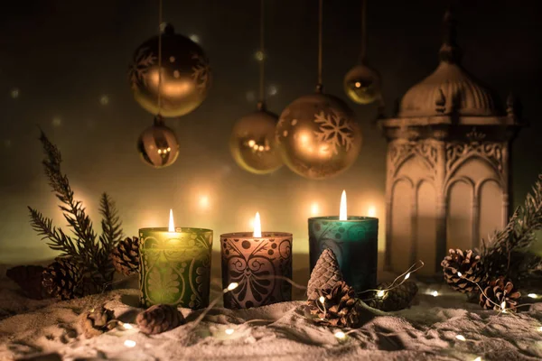 Decoração de arte criativa. Decoração de Natal com velas acesas em um fundo escuro. Enfeites de Natal sobre fundo dourado escuro com luzes . — Fotografia de Stock