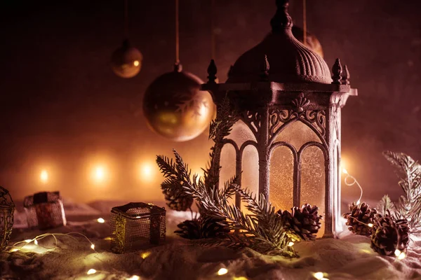 Творческое художественное оформление. Рождественское украшение с горящими свечами на темном фоне. Рождественские украшения на темно-золотом фоне с огнями . — стоковое фото