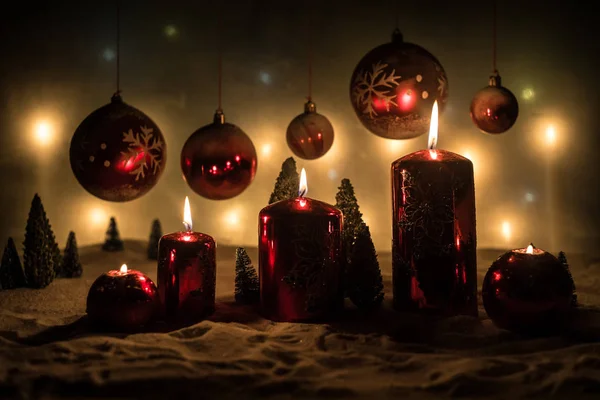 Creatieve kunstwerk decoratie. Kerstversiering met brandende kaarsen op een donkere achtergrond. Kerst ornamenten over donker gouden achtergrond met verlichting. — Stockfoto