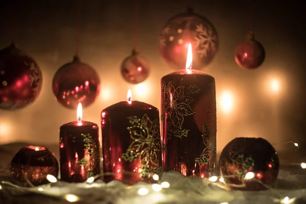 Decoración artística creativa. Decoración navideña con velas encendidas sobre un fondo oscuro. Adornos navideños sobre fondo dorado oscuro con luces . —  Fotos de Stock