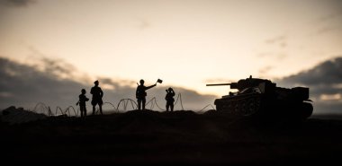 Savaş Konsepti. Savaş sis gökyüzü arka plan üzerinde sahne mücadele Askeri siluetler, Gece Bulutlu Skyline Altında Dünya Savaşı Alman Tankları Siluetler. Saldırı sahnesi.