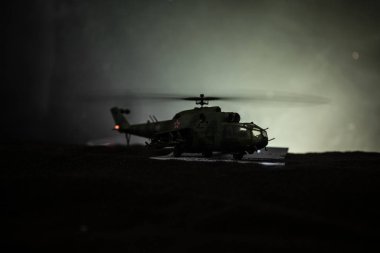 Askeri helikopter çatışma bölgesinden uçmaya hazır silüeti. Gece görüntüleri çöl sisli tonda sırt ile başlayarak helikopter ile dekore edilmiştir. Seçici odak.