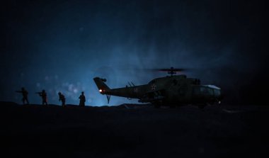 Askeri helikopter çatışma bölgesinden uçmaya hazır silüeti. Gece görüntüleri çöl sisli tonda sırt ile başlayarak helikopter ile dekore edilmiştir. Seçici odak.