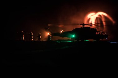 Askeri helikopter çatışma bölgesinden uçmaya hazır silüeti. Gece görüntüleri çöl sisli tonda sırt ile başlayarak helikopter ile dekore edilmiştir. Seçici odak.
