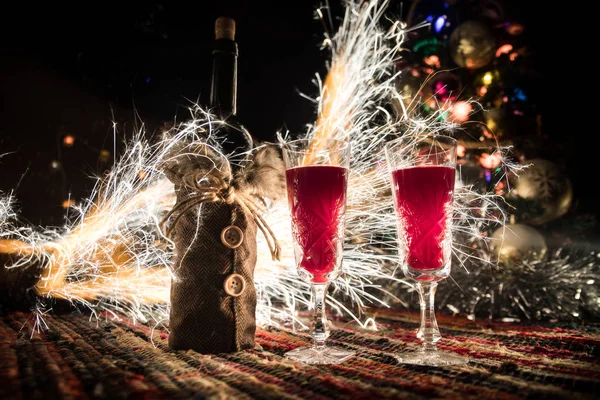 Vino tinto en cristal con botella en alfombra de colores con decoraciones creativas de Año Nuevo. Copiar espacio — Foto de Stock