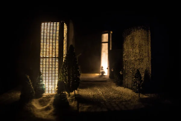 Kleine Miniaturstadt mit Straße und Licht. Dekorative niedliche Häuschen im Schnee in der Nacht im Winter. Kreatives Ferienkonzept. Weihnachten und Neujahr mit geschmückter Komposition. — Stockfoto