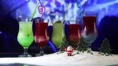 Yeni yıl ve Noel partisi konsepti. Farklı lezzetli kokteyller ve arka planda yeni yıl için sanat eserleri. Camda renkli bir kokteyl. Parti kulübü eğlencesi. Anlaşıldı. 