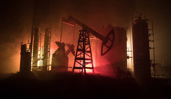 Artwork decoration. Oil pump and oil rig energy industrial machines for petroleum at night with fog and backlight. Oil refining factory. Energy industrial concept. Selective focus