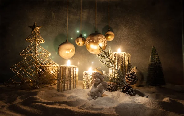 Dekoracja dzieł sztuki. Dekoracja świąteczna z płonącymi świecami na ciemnym tle. Ozdoby świąteczne na ciemnym złotym tle ze światłami. — Zdjęcie stockowe