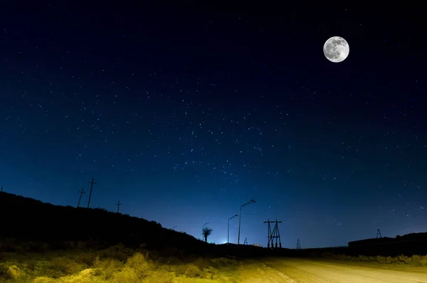 Lång exponering skott. Mountain Road genom skogen på en fullmåne natt. Natursköna nattlandskap med mörkblå himmel med måne. Azerbajdzjan — Stockfoto