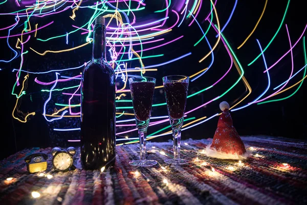 Червоне вино в кришталевому склі з пляшкою на барвистому килимі з творчими новорічними прикрасами. Копіювати простір — стокове фото