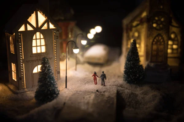 Casa en miniatura de Año Nuevo en la nieve por la noche con abeto. Concepto de vacaciones. Enfoque selectivo — Foto de Stock