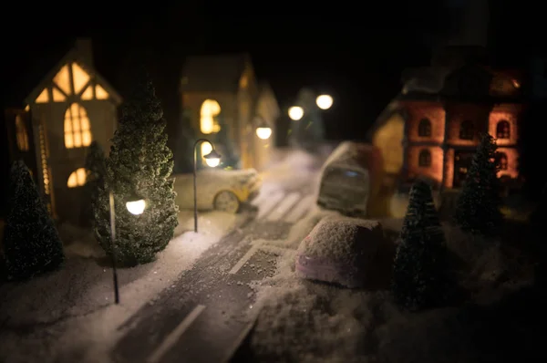 Casa en miniatura de Año Nuevo en la nieve por la noche con abeto. Concepto de vacaciones. Enfoque selectivo —  Fotos de Stock