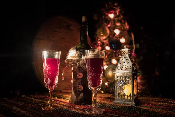 Vin rouge en verre de cristal avec bouteille sur tapis coloré avec des décorations créatives du Nouvel An. Espace de copie — Photo