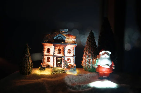 New Year miniature house in the snow at night with fir tree. Holiday concept. Selective focus — Stock Photo, Image