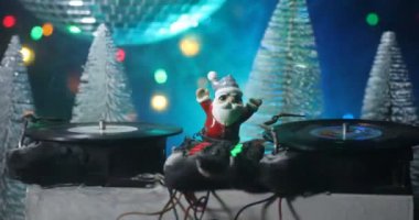 Noel Baba figürü ve renkli ışıklar altında DJ karıştırma tahtasıyla Noel kompozisyonu yakın çekim görüntüleri