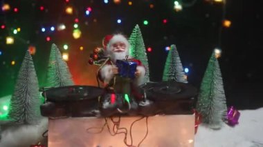 Noel Baba figürü ve renkli ışıklar altında DJ karıştırma tahtasıyla Noel kompozisyonu yakın çekim görüntüleri