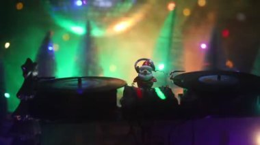 Noel Baba figürü ve renkli ışıklar altında DJ karıştırma tahtasıyla Noel kompozisyonu yakın çekim görüntüleri