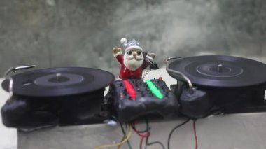 Noel Baba figürü ve renkli ışıklar altında DJ karıştırma tahtasıyla Noel kompozisyonu yakın çekim görüntüleri