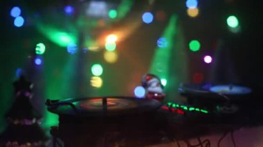 Noel Baba figürü ve renkli ışıklar altında DJ karıştırma tahtasıyla Noel kompozisyonu yakın çekim görüntüleri