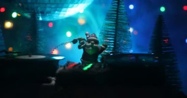 Noel Baba figürü ve renkli ışıklar altında DJ karıştırma tahtasıyla Noel kompozisyonu yakın çekim görüntüleri