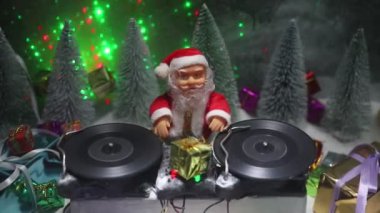 Noel Baba figürü ve renkli ışıklar altında DJ karıştırma tahtasıyla Noel kompozisyonu yakın çekim görüntüleri