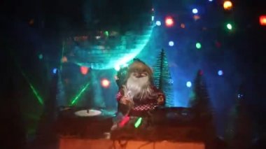 Noel Baba figürü ve renkli ışıklar altında DJ karıştırma tahtasıyla Noel kompozisyonu yakın çekim görüntüleri