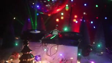 Noel Baba figürü ve renkli ışıklar altında DJ karıştırma tahtasıyla Noel kompozisyonu yakın çekim görüntüleri
