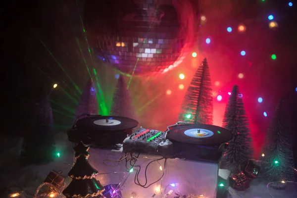 Μείκτης για DJ με ακουστικά σε φόντο σκοτεινό νυχτερινό κέντρο διασκέδασης με Χριστουγεννιάτικο δέντρο το νέο έτος Eve. Κλείνω πάνω θέα του έτους νέα στοιχεία σε ένα τραπέζι του Dj. Holiday κόμμα έννοια. Κενός χώρος — Φωτογραφία Αρχείου