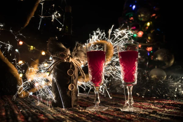 Vino tinto en cristal con botella en alfombra de colores con decoraciones creativas de Año Nuevo. Copiar espacio — Foto de Stock