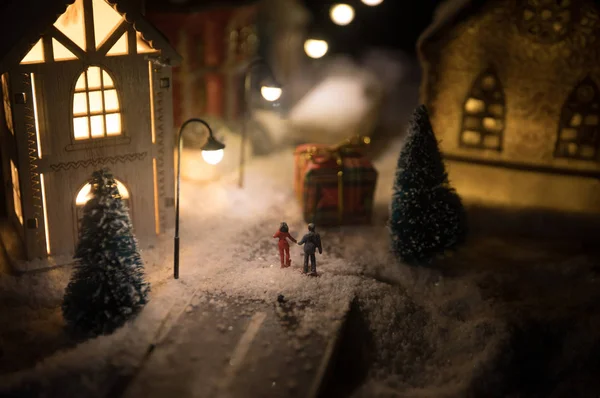 Casa en miniatura de Año Nuevo en la nieve por la noche con abeto. Concepto de vacaciones. Enfoque selectivo —  Fotos de Stock