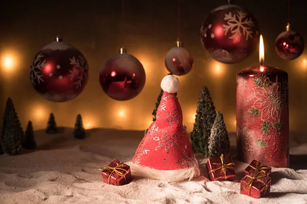 Decoración artística creativa. Decoración navideña con velas encendidas sobre un fondo oscuro. Adornos navideños sobre fondo dorado oscuro con luces . — Foto de Stock