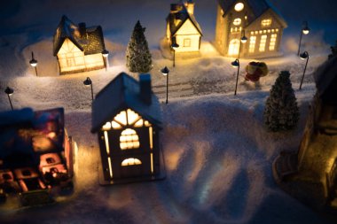 Yeni yıl minyatür evi, geceleri karlı ve köknar ağacıyla kaplı..