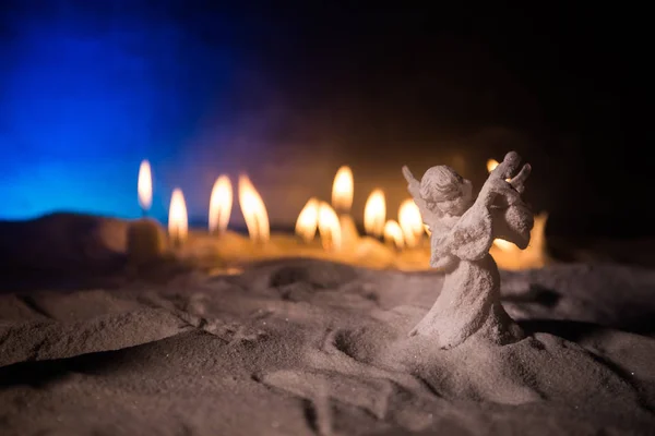 Little white guardian angel in snow. Festive background. Christmas and New Year concept. Selective focus