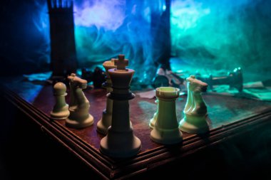 Duman ve sisli karanlık bir arka planda satranç figürleri. Seçici odak