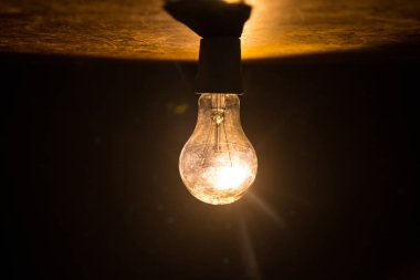 Parlayan ampullerin yaratıcı sanat dekorasyonuna sahip soyut koyu arkaplan.