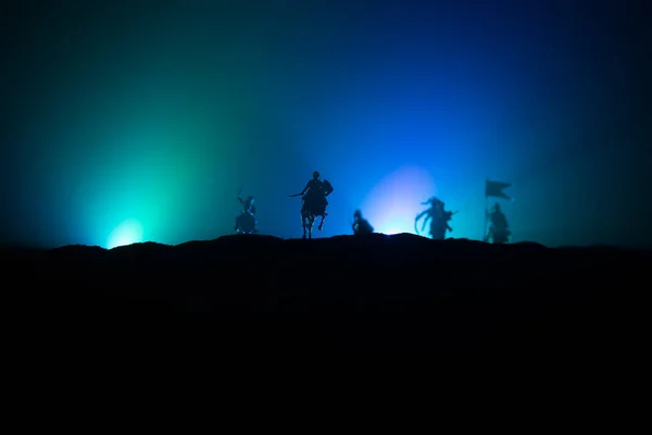 Mittelalterliche Kampfszene mit Kavallerie und Infanterie. Silhouetten von Figuren als separate Objekte, Kampf zwischen Kriegern auf dunkel getöntem nebeligen Hintergrund. Nachtszene. — Stockfoto