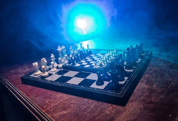 Figuras de xadrez em um fundo escuro com fumaça e nevoeiro. Foco seletivo — Fotografia de Stock