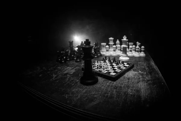 Figuras de xadrez em um fundo escuro com fumaça e nevoeiro. Foco seletivo — Fotografia de Stock