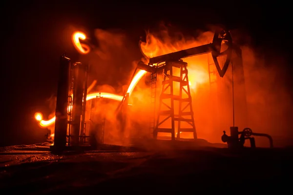 Decoração de obras de arte. Bomba de óleo e equipamento de óleo máquinas industriais de energia para petróleo à noite com nevoeiro e luz de fundo. Fábrica de refinação de petróleo. Conceito industrial de energia. Foco seletivo — Fotografia de Stock