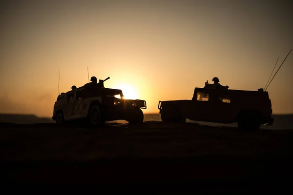 夕日を背景に軍事パトロール車。軍隊戦争の概念。兵士を攻撃する準備ができてがある装甲車のシルエット。アートワークの装飾。選択と集中 — ストック写真