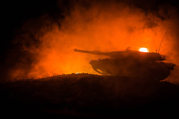 War Concept. Armored vehicle silhouette fighting scene on war foggy sky background at night. American tank ready to fight.