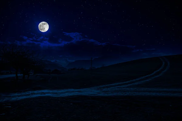 Paisagem noturna cênica de estrada rural à noite com grande lua — Fotografia de Stock