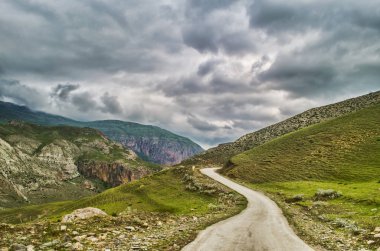 Dağ yolundan Bisiklete binme. Puslu dağ yolu yüksek dağlarda... Dağ yolu ile bulutlu gökyüzü