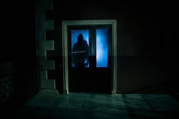 La silhouette di un umano davanti a una finestra di notte. Scena spaventosa concetto di Halloween di silhouette sfocata di maniaco . — Foto Stock