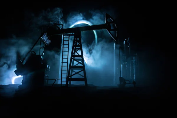 Décoration d'art. Pompe à huile et machines industrielles d'énergie de plate-forme pétrolière pour le pétrole la nuit avec brouillard et contre-jour. Usine de raffinage de pétrole. Concept énergétique industriel. Concentration sélective — Photo