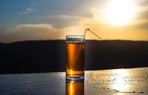 Raffreddamento concetto di bevanda estiva. Bicchieri da cocktail che schizzano al tramonto. Chiudi il bicchiere bagnato di bevanda fredda sulla terrazza . — Foto Stock