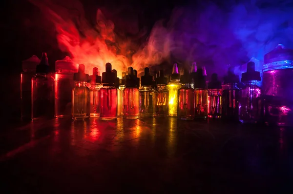Füstfelhők és gőz folyékony palackok sötét háttérrel. Fényhatások. Hasznos, mint a háttér vagy gőz reklám vagy gőz háttér. Szelektív fókusz — Stock Fotó