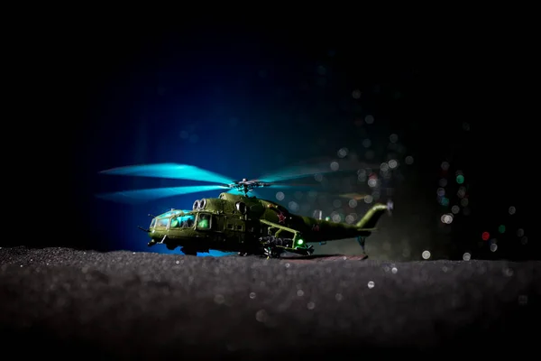 Silhouette of military helicopter ready to fly from conflict zone. Decorated night footage with helicopter starting in desert with foggy toned backlit. Selective focus. — Stock Photo, Image