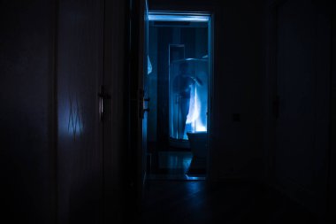 Cadılar Bayramı konsepti Duş kabinindeki korkunç insan silueti. Parlayan ışıkları olan katil manyak banyoda. Uzun pozlama